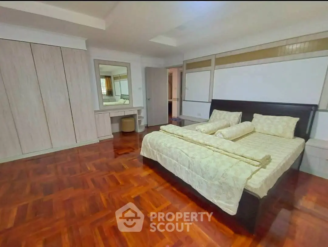 Spacious bedroom with elegant wooden flooring and modern furnishings