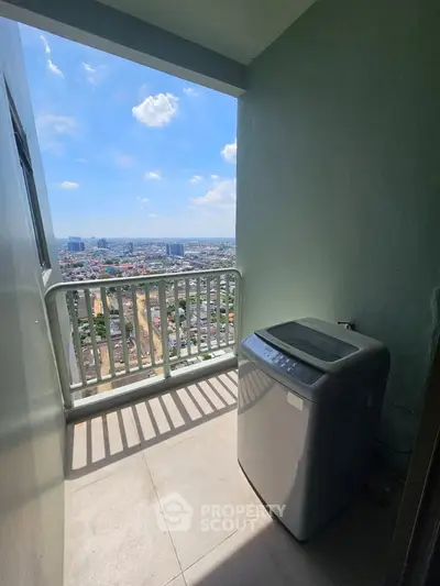 High-rise balcony with washing machine and panoramic city view under clear blue sky.