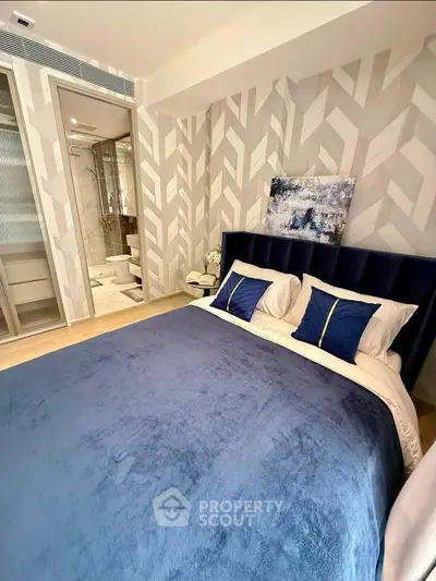 Luxurious bedroom with modern decor and ensuite bathroom in a stylish apartment.