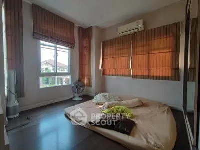 Cozy bedroom with large windows and air conditioning, perfect for relaxation.