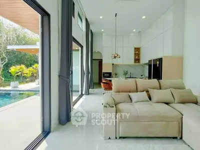 Luxurious open-plan living room with pool view and modern kitchen