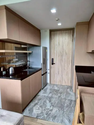 Modern kitchen with sleek cabinetry and stainless steel appliances in a compact layout.