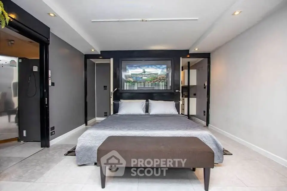 Modern bedroom with sleek design and neutral tones, featuring a comfortable bed and stylish decor.