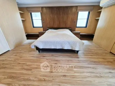 Spacious bedroom with wooden flooring and modern design