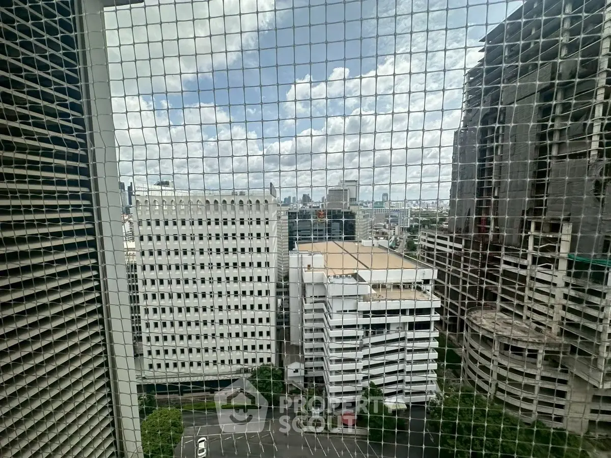 Stunning cityscape view from high-rise building with urban skyline and cloudy sky.