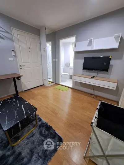 Modern living room with stylish decor and wall-mounted TV in a cozy apartment.