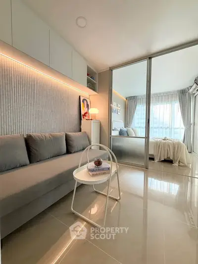 Modern living room with sleek design and cozy bedroom view, featuring elegant lighting and stylish decor.
