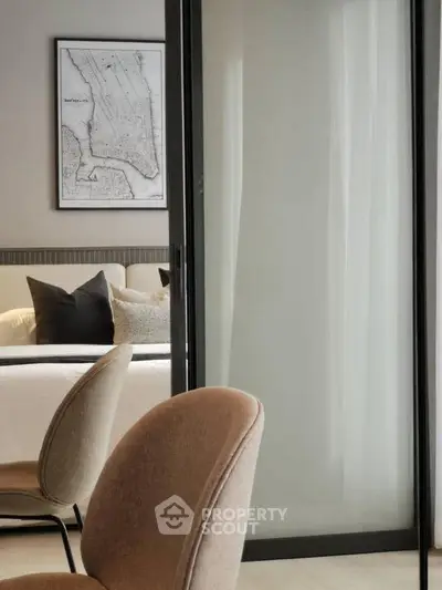 Modern bedroom with stylish decor and elegant seating, featuring a map artwork on the wall.