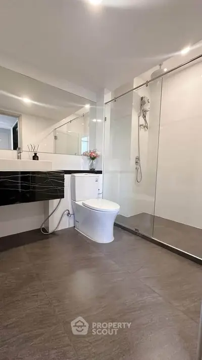 Modern bathroom with sleek design, glass shower enclosure, and elegant fixtures.