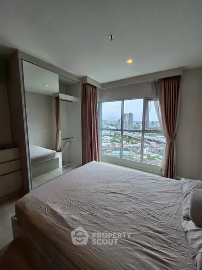 Spacious bedroom with city view and large window, perfect for urban living.