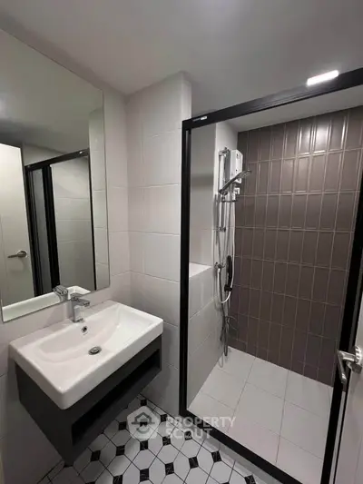 Modern bathroom with sleek shower and stylish sink in contemporary apartment.