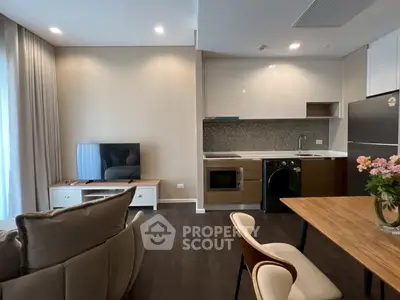 Modern open-plan living room and kitchen with sleek appliances and stylish decor.