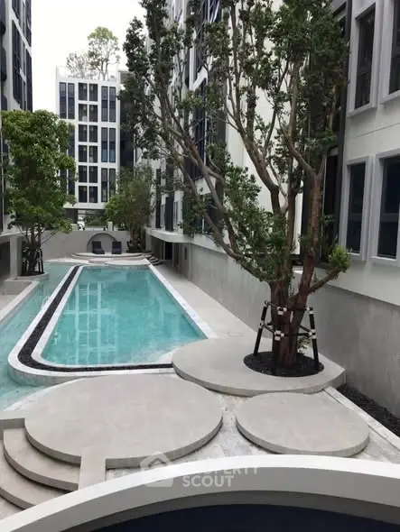 Modern apartment complex with sleek pool and lush greenery