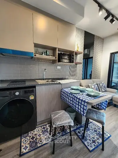Modern kitchen with compact dining area and washing machine, featuring stylish decor and efficient layout.