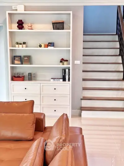 Stylish modern living room with leather sofa and elegant staircase