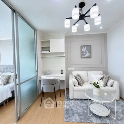Modern living room with stylish decor and cozy seating area, featuring a chic chandelier and elegant furnishings.