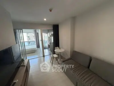 Modern living room with sleek furniture and balcony view in a stylish apartment.