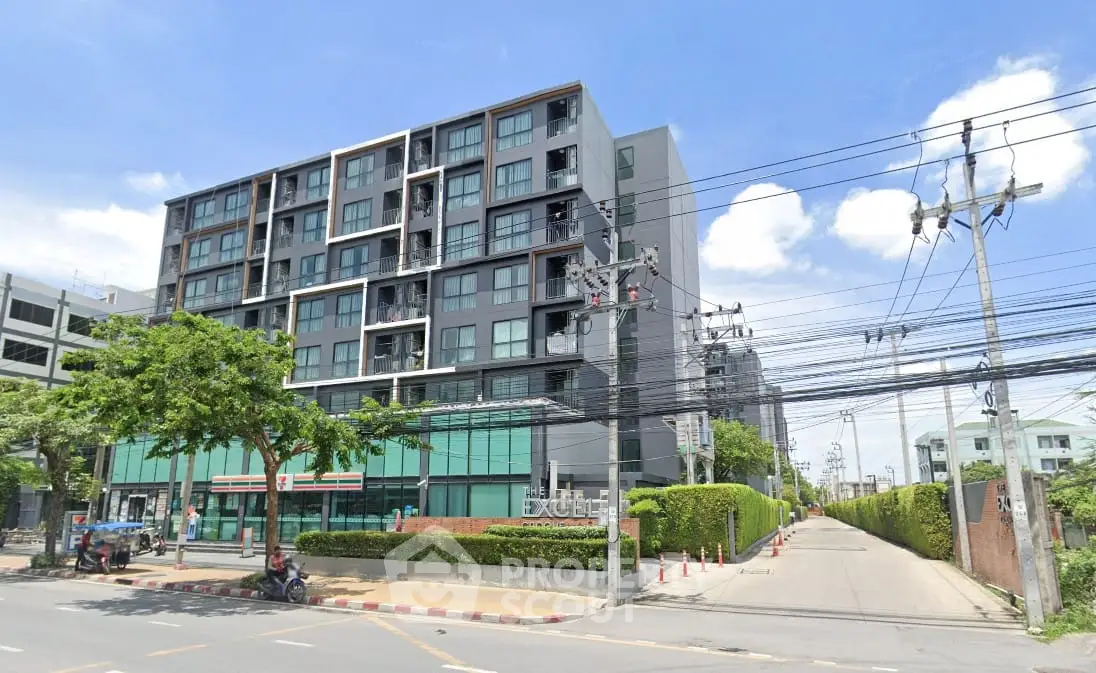 Modern apartment building with sleek design and lush greenery in urban setting.