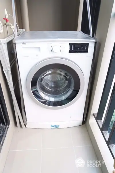 Modern washing machine in a compact laundry area with natural light