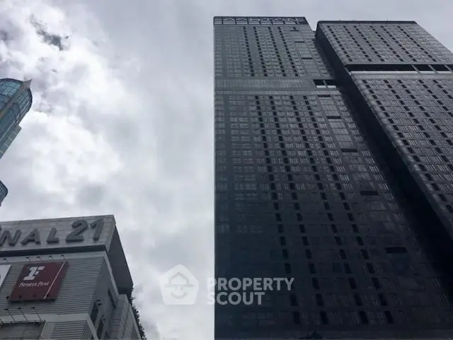 Stunning skyscraper with modern architecture and sleek design against a cloudy sky.