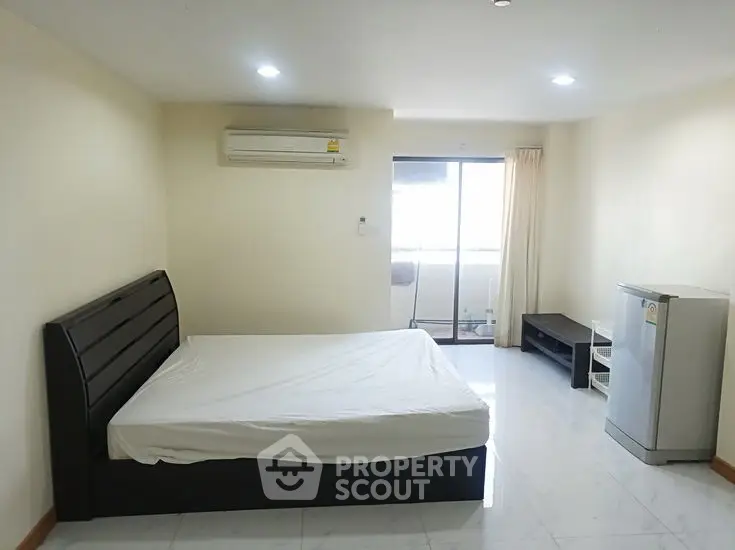 Spacious bedroom with modern furnishings and balcony access