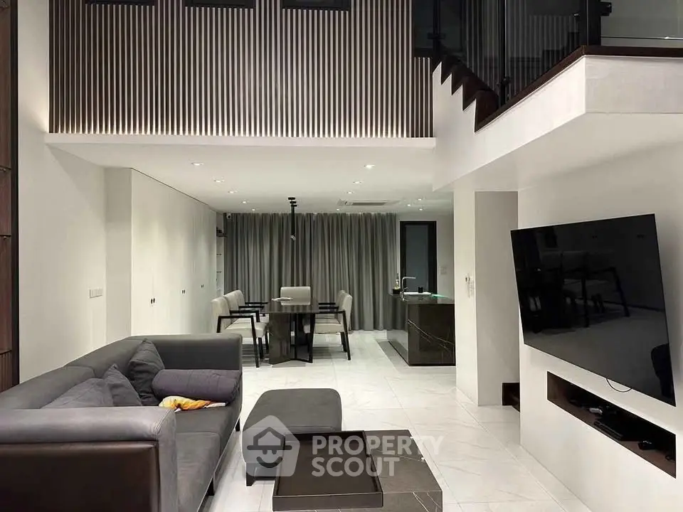 Luxurious modern living room with high ceilings, sleek furniture, and open dining area, perfect for entertaining.