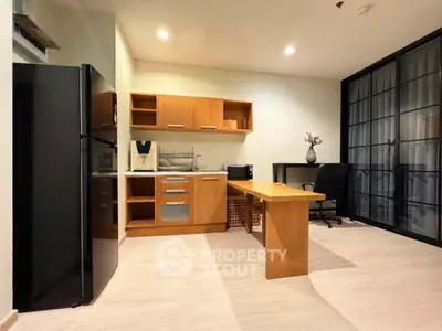 Modern kitchen with sleek black fridge and wooden cabinetry in open layout design