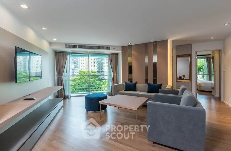 Spacious modern living room with large windows and stylish furniture, offering a bright and inviting atmosphere.