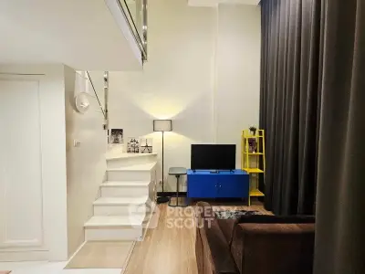 Modern living room with stylish decor and staircase in a cozy apartment