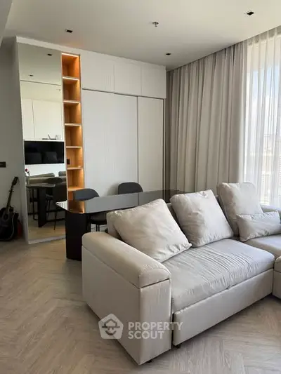 Modern living room with cozy sofa and elegant dining area, featuring floor-to-ceiling curtains and stylish decor.