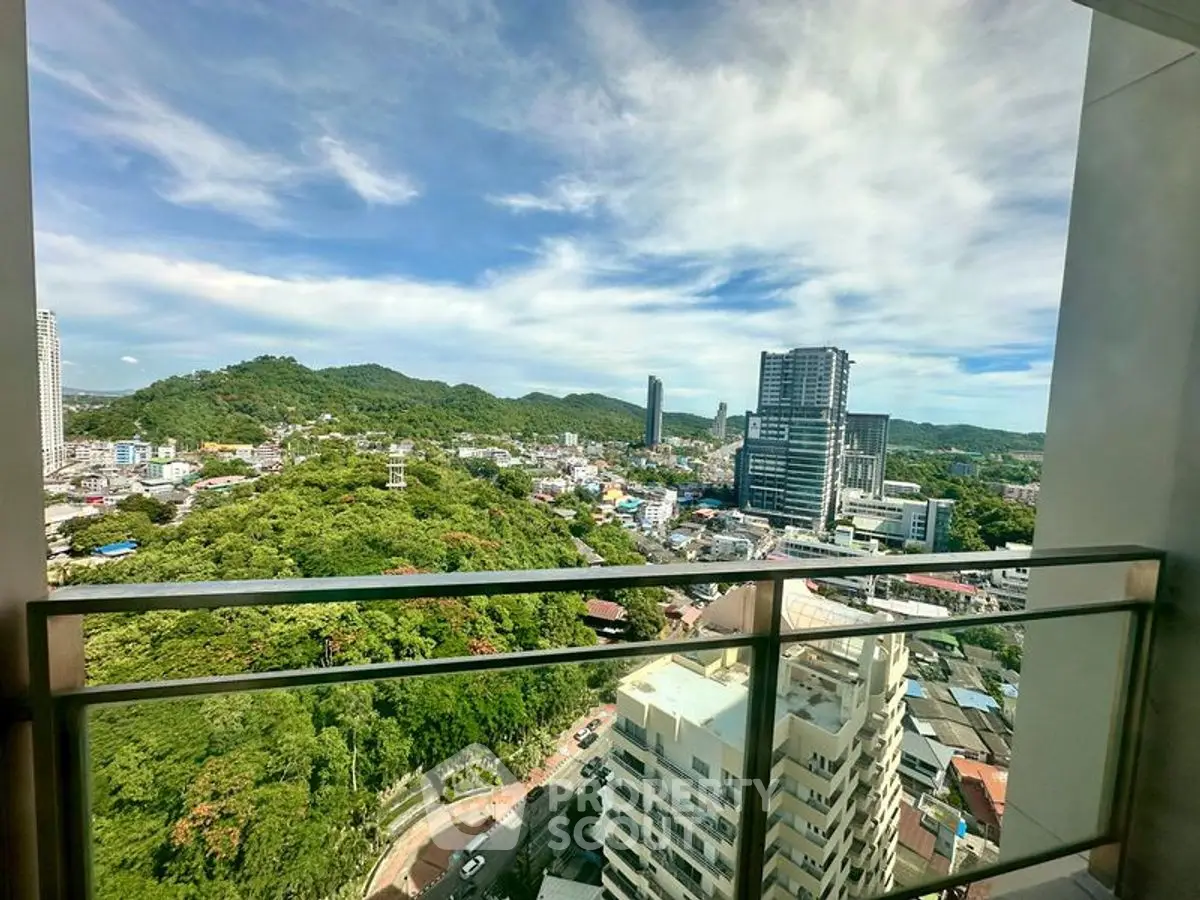 Stunning cityscape view from high-rise balcony with lush greenery and skyline.