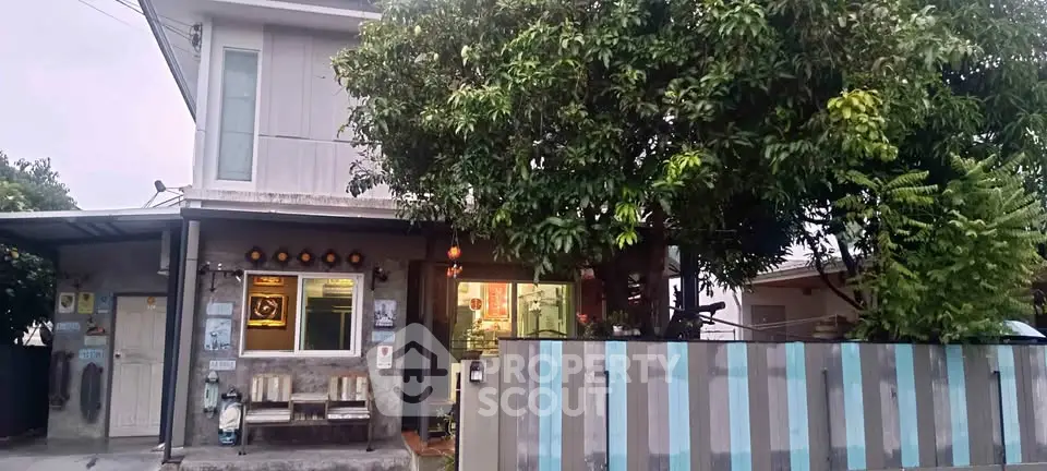 Charming two-story house with lush greenery and modern facade