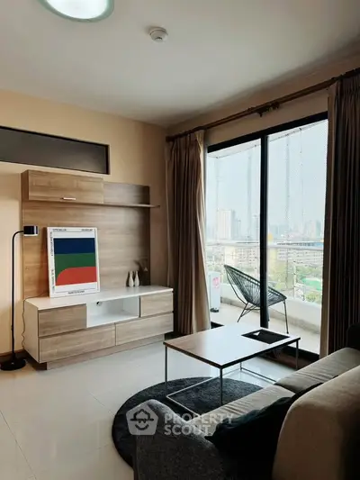 Modern living room with large windows and city view, featuring stylish furniture and decor.