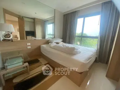 Modern bedroom with large window and stylish decor in a cozy apartment.