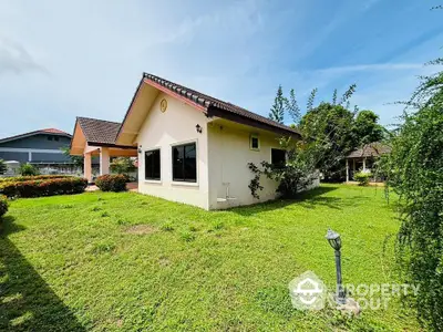 Charming single-story house with lush green garden and spacious yard, perfect for family living.