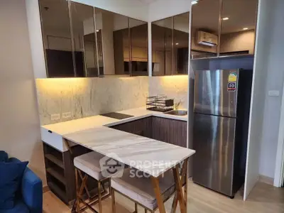 Modern kitchen with marble countertops and stainless steel appliances in a stylish apartment.