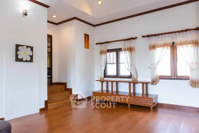 Spacious living room with wooden flooring and elegant curtains