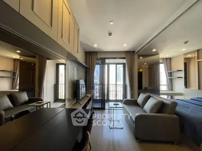 Modern studio apartment with open layout, featuring a cozy living area and balcony with city views.