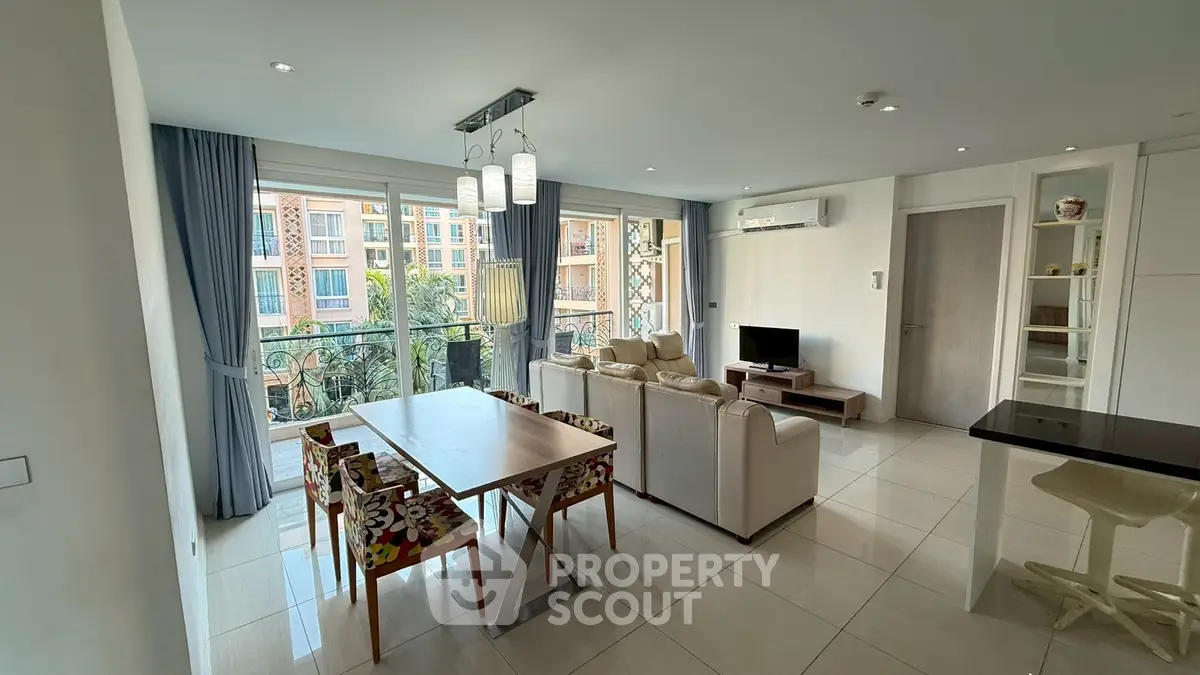 Spacious living room with modern decor and balcony view in luxury apartment.