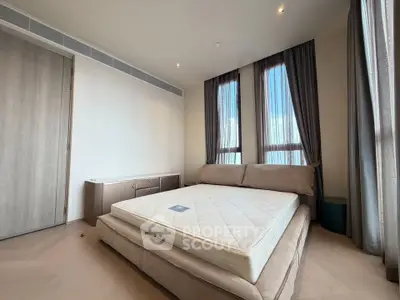 Spacious bedroom with large windows and modern furnishings in a luxury apartment.