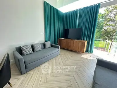 Modern living room with stylish furniture and large windows offering a serene garden view.