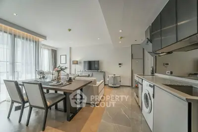 Modern open-plan living room and kitchen with elegant dining area and natural light.