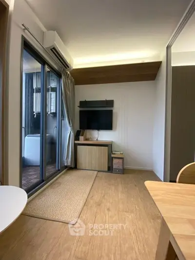 Modern living room with wooden flooring and balcony access in stylish apartment