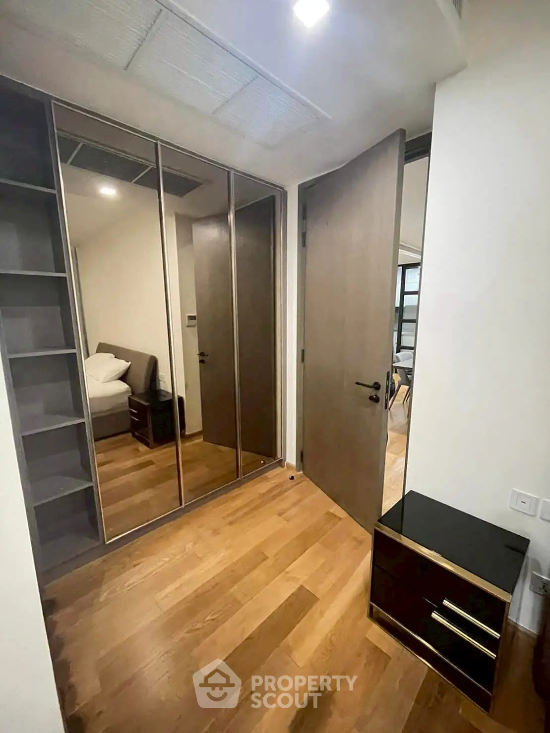 Modern bedroom with mirrored closet doors and wooden flooring
