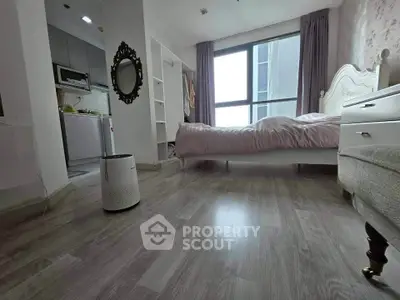 Spacious bedroom with modern decor and natural light, featuring a cozy bed and sleek flooring.