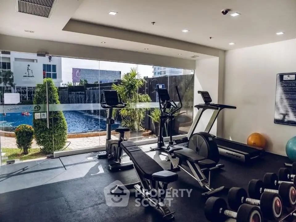 Modern gym with pool view in luxury residential complex