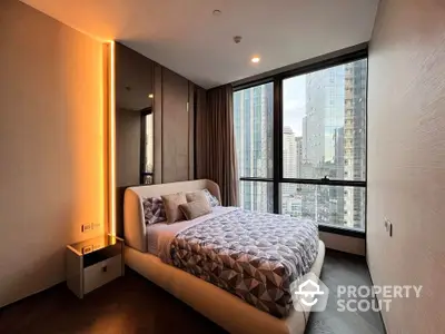 Modern bedroom with city view, featuring stylish decor and large windows in a high-rise apartment.