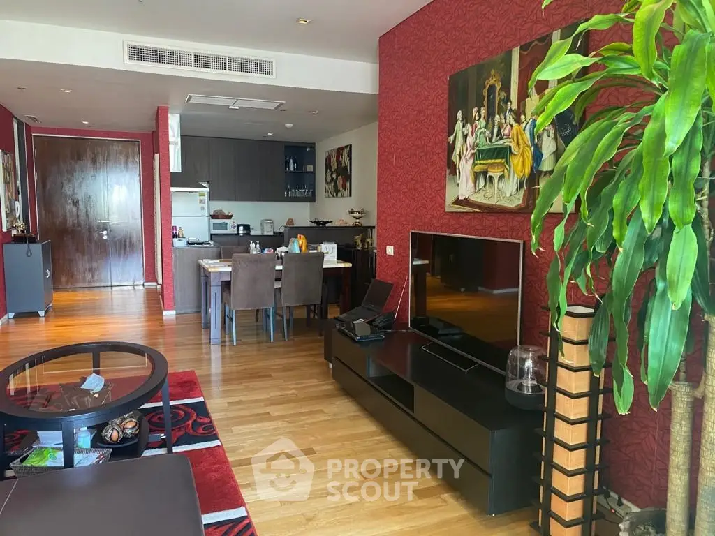 Spacious living room with modern decor and open kitchen layout, featuring hardwood floors and stylish furniture.