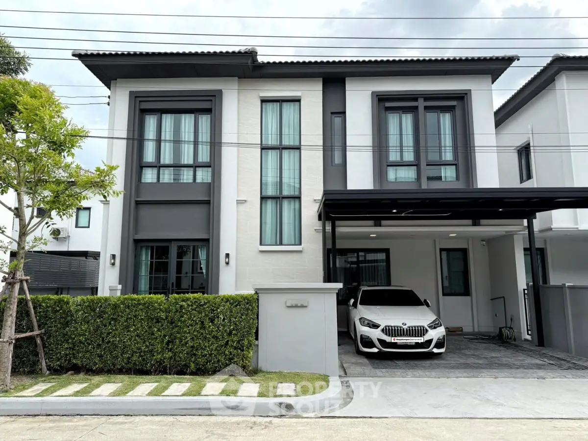 Modern two-story house with sleek design and attached garage in a suburban neighborhood.