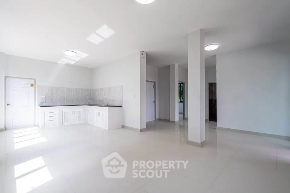 Spacious open-plan living area with modern kitchen and ample natural light.